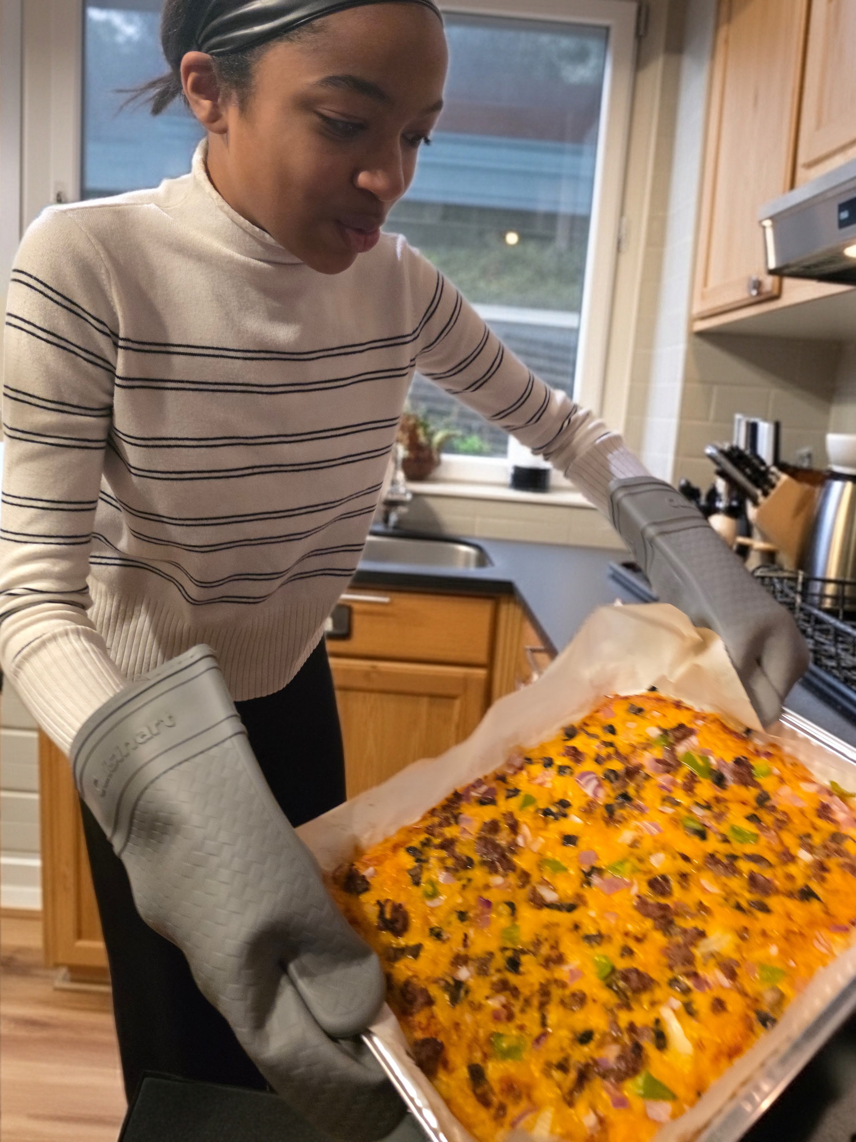 Moriah pulling a fresh bake from the oven
